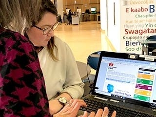 Elizabeth Davis, Head of Circulation and Access Services for Hartford Public Library, (left) explains the library pass program, which offers free Hartford Stage tickets to Hartford residents with library cards to a patron