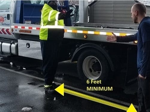 Technician Manny Beatty and supervisor Dan Chrzanowski of AAA's Rhode Island fleet demonstrate social distancing.