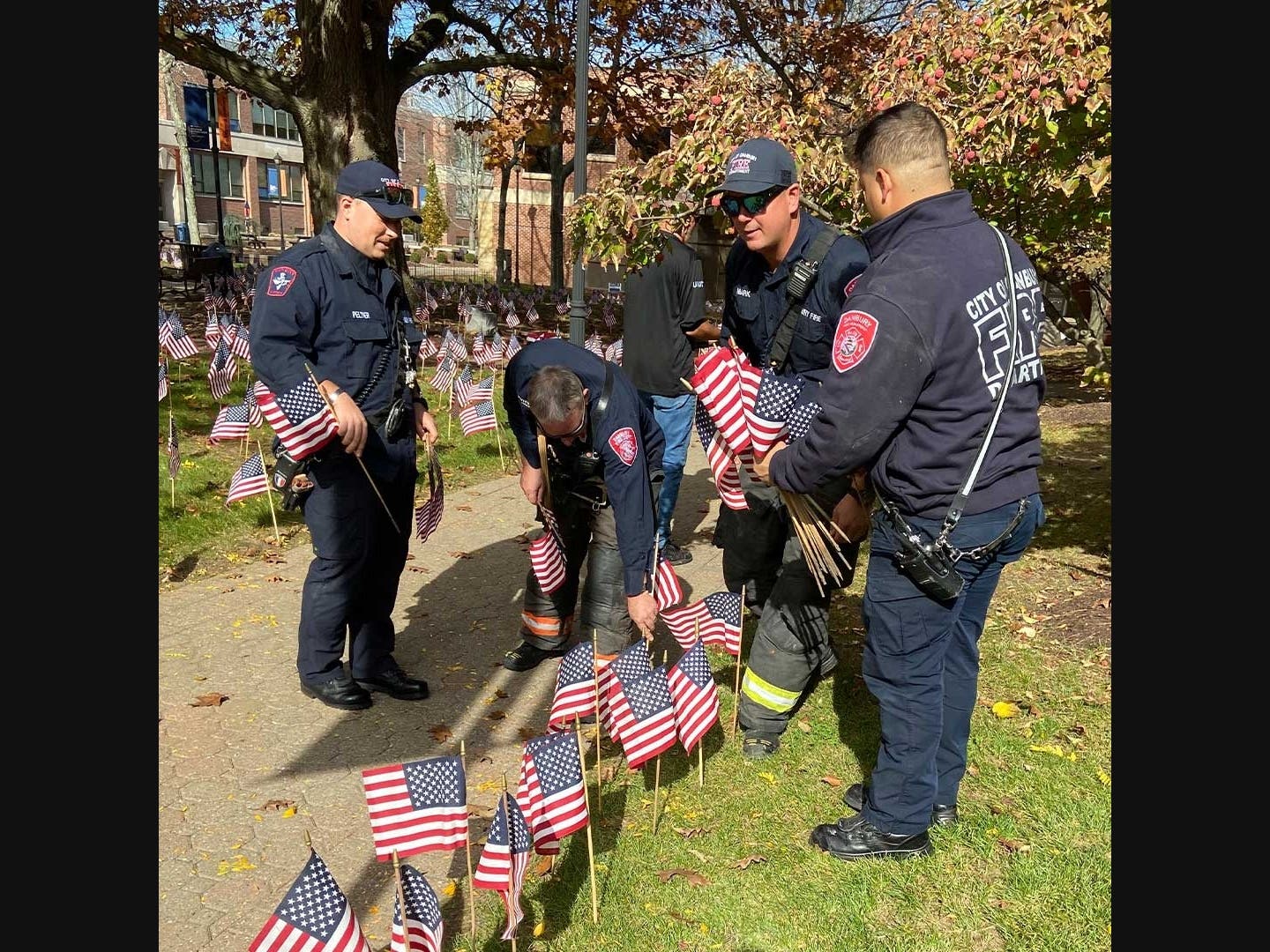  Members of the Danbury Fire Department joined WCSU students, faculty and staff in placing American flags in the university’s Field of Flags to honor veterans.