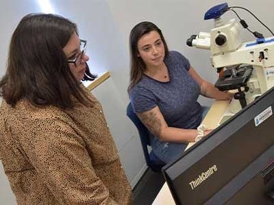  WCSU Associate Professor of Biology Dr. Kristin Giamanco works with a student in the Microscopy Lab.  