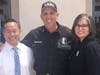 A uniformed police office poses for a campaign picture with City Council members John Lee and Monica Rodriguez