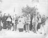 Members walk across the street and down the block to the third church building bearing worship items from the previous sanctuary.