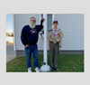 Greg Schlachter with Eagle Scout Jacob Boivin at the flagpole they refurbished in memory of WWII veteran Harry Schlachter.