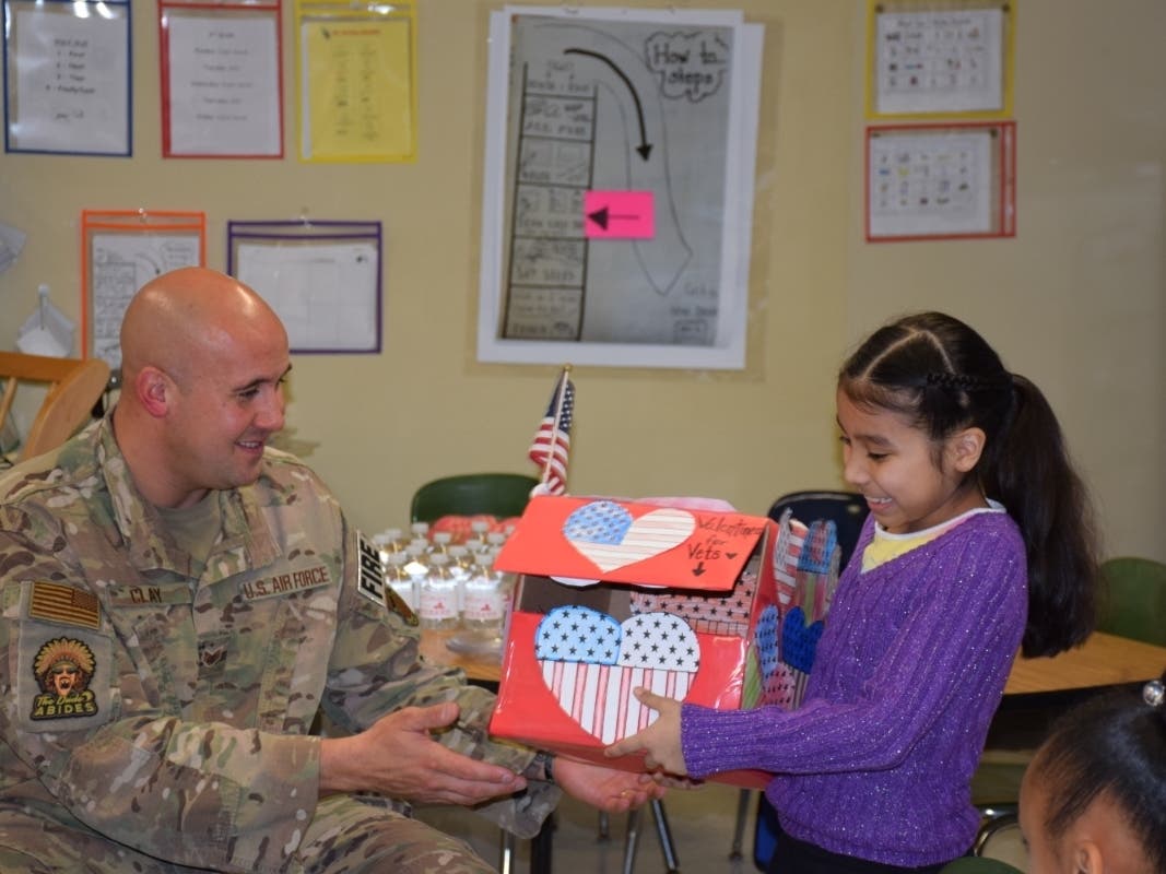 Staff Sergeant Chris Clay accepting hundreds of valentines from Roanoke Elementary School student council member Lindsey Garcia Bailey.