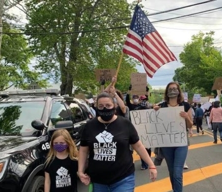Lisa Votino, who is organizing Sunday's event, and her daughter Lily march in a rally held in Bridgehampton last week.