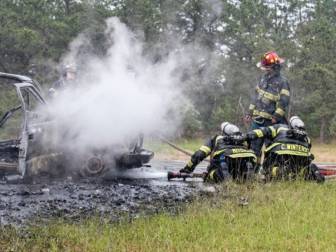 Westhampton Beach firefighters extinguish the last flames of a vehicle fire on Sunrise Highway. 