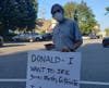 Carrying signs, a group of about 60 protesters turned out as President Donald Trump was hosting a fundraiser in the Hamptons Saturday.