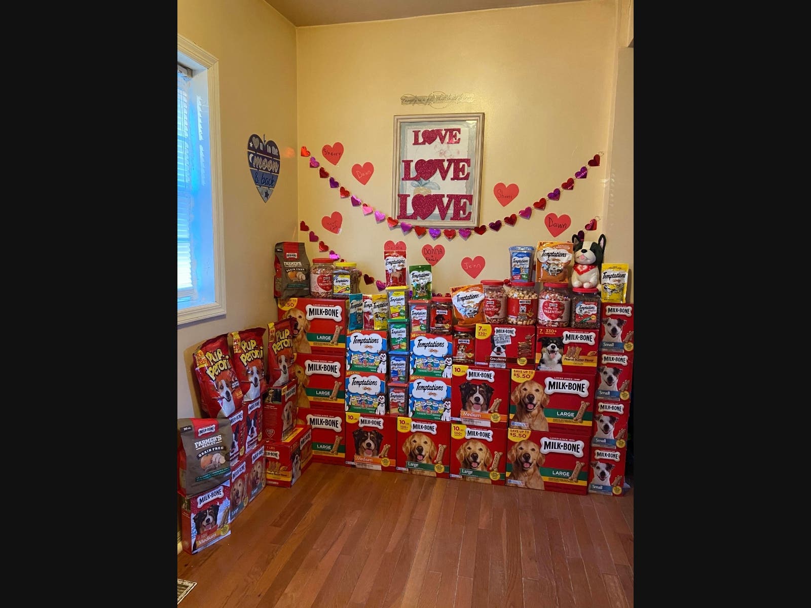 The wall of love is growing as a caring volunteer collects Valentine's Day treats for cats and dogs.