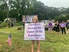 Kadence, who lost her mother and grandmother in crashes, at a rally supporting a sign that advocates for safety on the roads.