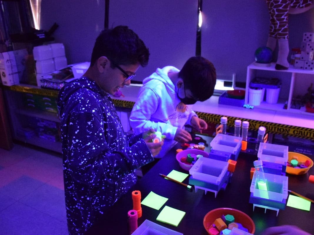 The lab was fully aglow with fluorescent, black-lit learning stations aimed at sparking engagement, the district said.