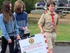 Kevin, Ryan, and Mallaigh, grandchildren of 1st Lt. George Sullivan, carried a sign in his honor.
