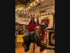 Kylie O'Brien enjoys a ride on the festive carousel at The Shoppes at East Wind.