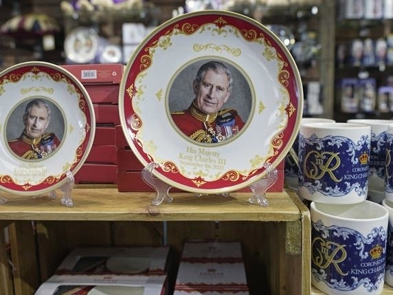 Coronation plates and mugs are displayed for sale in a gift shop in London, Monday, April 24, 2023. Fans looking to remember the historic event can find everything from fine china to souvenir coins or even cardboard masks of Charles and Camilla. 