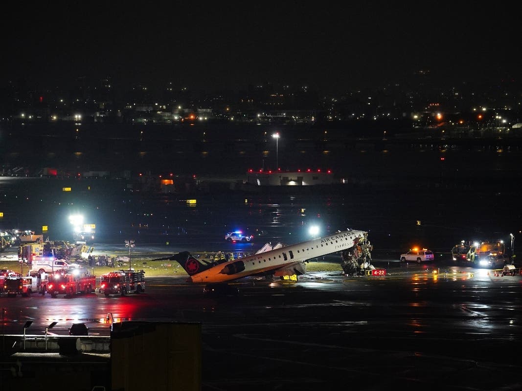 A Port Authority aircraft rescue and firefighting vehicle lays on its side off of runway 4 after colliding with an Air Canada jet after it landed at LaGuardia Airport, Monday.