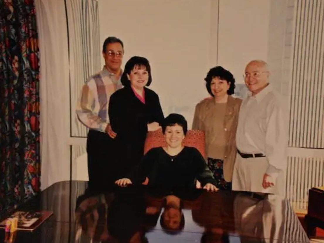 A photo of Paula DiDonato, her office and family, with the Twin Towers in the background.