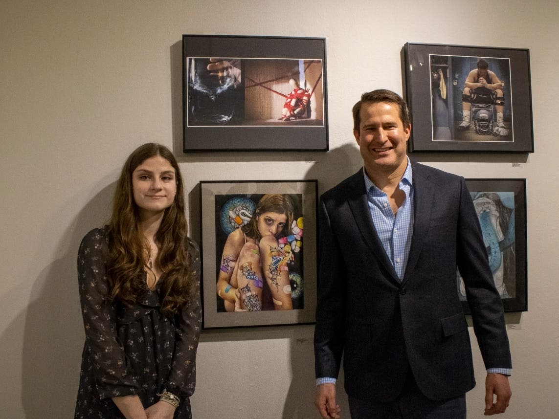 Last year's winner, Emma Condon, alongside her winning piece and 6th District Congressman Seth Moulton