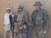 Major Jasmine Motupalli, center, with local children and another G.I. in Afghanistan.