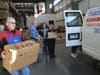 Better Packages, Inc. CEO Philip White loads up a van for the St. Vincent de Paul  Food Bank with a box of fresh produce. 