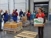 Director of Support Services Lorrie Hoak carries a box of healthy food.