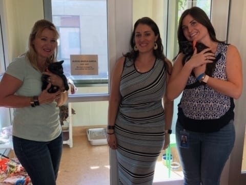Lexy Garcia's mother, Kinga, and sisters Karyn and Kristyn pose in front of "Lexy's Room" at the East Bay SPCA.