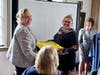 Lucinda Tomko presenting documents to Kellie Santiago, Executive Director, Derby
Historical Society. SRH-MS Chapter Regent Jeaneen Buchanan at podium.