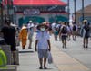 Calvin Quach, of Westminster, wears a mask while walking under the pier in Huntington Beach.