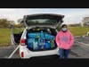 Hillcrest High School Key Club President standing with donated supplies