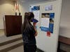A student listening to a description of a displayed poster
