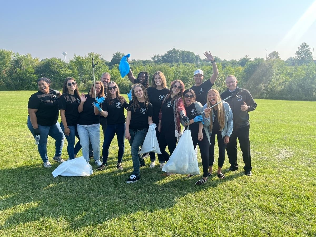 Delta Academy staff, Director Erin Collins, and Superintendent Dr. Sikora pose for a photo amid clean-up efforts.