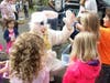 The Easter Bunny (Judy Farrell) high-fives some children at the Easter egg hunt.