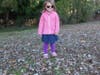 Lilly Garcia is surrounded by leaves at the Admiral Heights block party in Halsey Park. 
