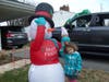 An inflatable snowman bops Chelsea Heier on the head with an inflatable ice cream cone. This snowman is one of many decorations in her yard which is all decked out for Christmas.