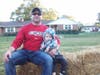 Mike Jolicoeur and his son, TJ, relax on a hay bale after making a scarecrow.

