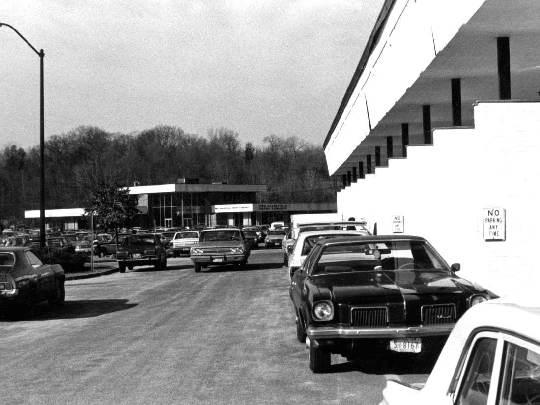 Black and white photo from the 1970s shows the campus with a parking lot in what later became the college’s courtyard. 