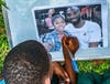A young Ugandan boy signs a photo of Kobe and Gianna