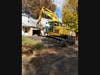 An excavator prepares to demolish a home at the Shenandoah Woods site.
