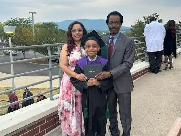 David Balogun poses with his parents Ronya and Henry after receiving his high school diploma during a ceremony earlier this month at Penn State University.