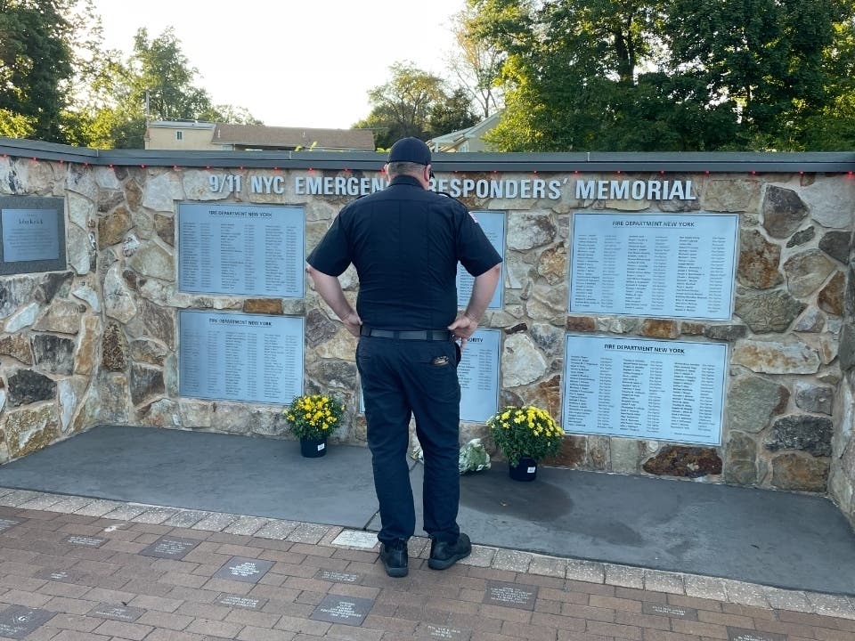 A First Responder pays his respects to the victims of the Sept. 11 attacks at the Hartsville Fire Company in Warminster on Friday afternoon.