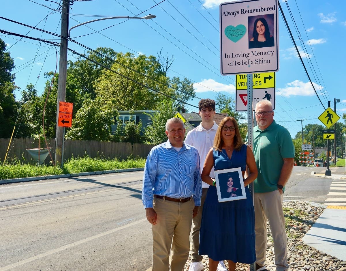 State Sen. Frank Farry stands with the Shinn family in front of the new crosswalk on Brownsville Rd. and dedication sign in memory of Isabella.