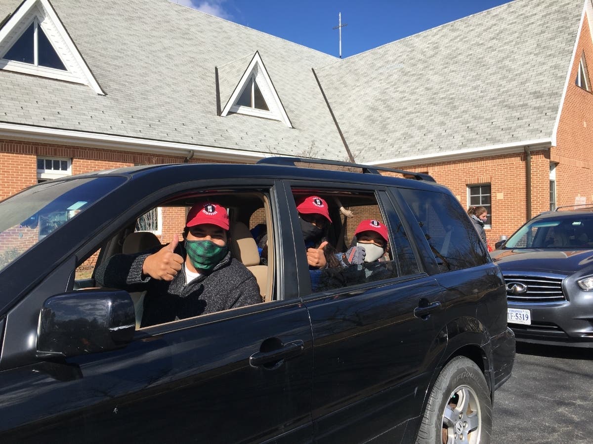 The D'Souzas give a big "thumbs up" after a morning of collecting food for hungry teens.