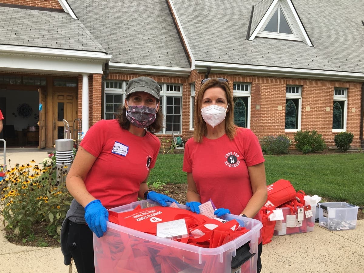 Food For Neighbors Driver Coordinator Erika Carlson (left) enjoys volunteering with Executive Director Karen Joseph (right) during a Red Bag Event on a sunny day.