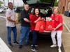 At Herndon Middle School, Donna Wilson (far right), Chief Financial Officer at ST Engineering iDirect, and her colleagues (from left to right) Derek Carpenter, Conor Foley, and Krista Phillips unload Red Bags filled with food and toiletries.