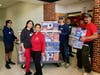 Fanny Salazar-Laske (center in red), the Family Liaison for Herndon Middle School, is excited to receive food into the school pantry she manages. Fanny puts her whole heart into helping students in need.