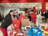 Fiona Gonsalvez, who coordinates the Red Bag Event in support of Herndon and Reston Area schools, joins other volunteers in unpacking and sorting food and toiletries.