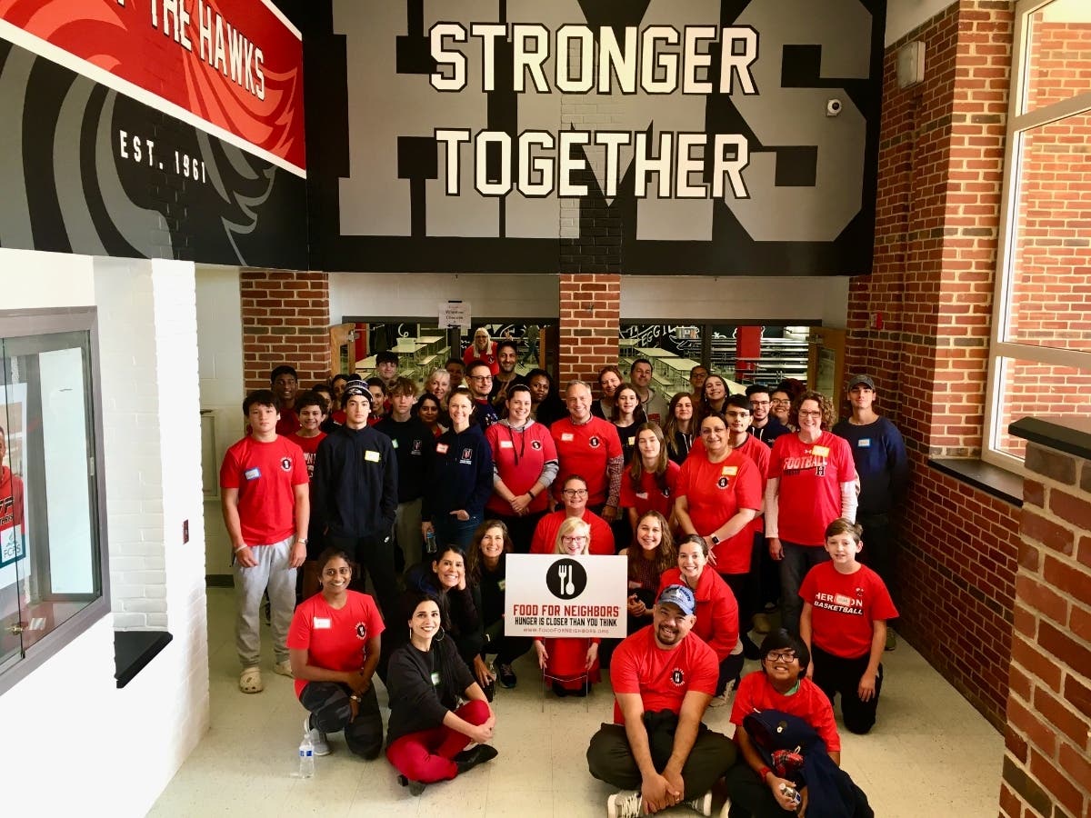 At Herndon Middle School, volunteers celebrate a morning of service to help provide food and toiletries for students in need.
