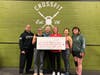 Food For Neighbors Founder Karen Joseph (right center) celebrates with Head Coach Julie Furneisen (left center), No Child Goes Hungry Founder Rev. Kären Rasmussen (back center), and other dedicated CrossFitters at CrossFit Fairfax, owned by Samrina Islam.