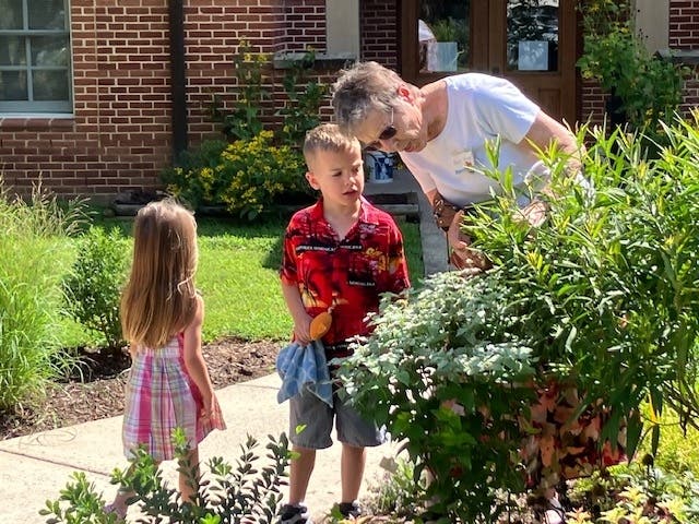 Nancy, a member of Trinity Presbyterian Church in Herndon, VA, helps young Miles and Bethany discover the wonders of the new butterfly garden.