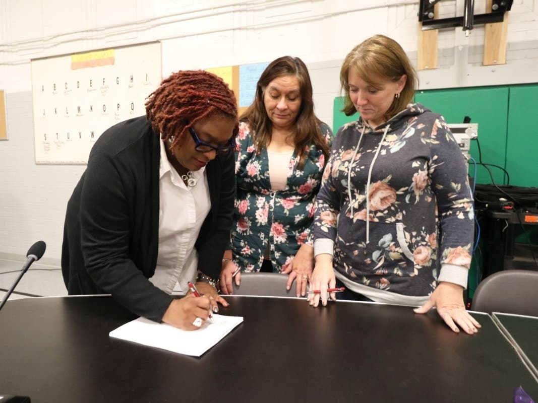 Joliet Public Schools District 86 Board of School Inspectors President Tonya Roberts, Joliet #86 School Related Personnel Council Union President Sofia Thomas, and Union Secretary Carla Dobson sign the new contract.