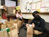 Lily Richter and Anthony Solache help package up bags of socks