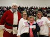 Santa, Amy Wendell-Blish, and Amy Johnson present Debbie Trimmer from Pink Heals with a check for $1,600.